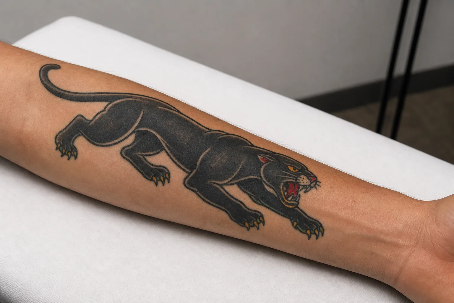 Crawling panther tattoo placed along a forearm